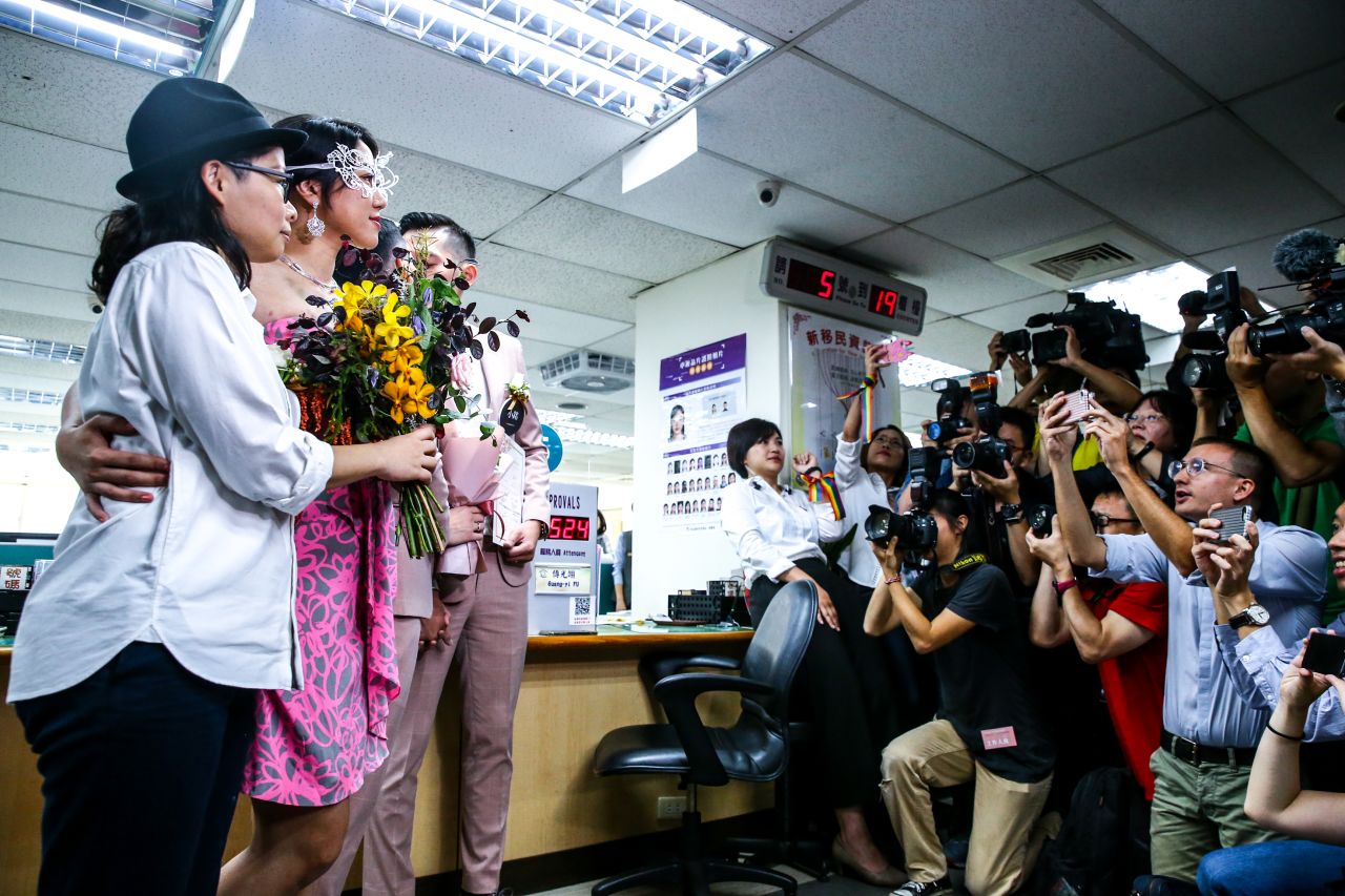 Photographers take pictures of newly married same-sex couples in the Household Registration Office in Shinyi District in Taipei on Friday.