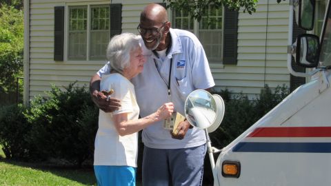 Lorraine Wascher, a stop on Martin's route for more than 20 years, shares a hug with the retiring worker.
