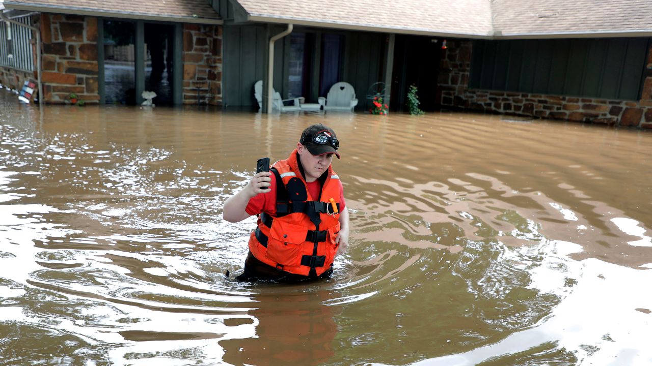 Deputy Miranda Munson returns to a boat after checking a flooded house Thursday in Sand Springs.