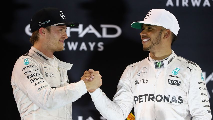 ABU DHABI, UNITED ARAB EMIRATES - NOVEMBER 27:  Race winner Lewis Hamilton of Great Britain and Mercedes GP shakes hands with second place finisher and F1 World Drivers Champion Nico Rosberg of Germany and Mercedes GP on the podium  during the Abu Dhabi Formula One Grand Prix at Yas Marina Circuit on November 27, 2016 in Abu Dhabi, United Arab Emirates.  (Photo by Clive Mason/Getty Images)