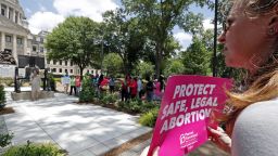 An abortion rights advocate holds signage at the Capitol in Jackson, Miss., voicing her opposition to state legislatures passing abortion bans that prohibit most abortions once a fetal heartbeat can be detected, Tuesday, May 21, 2019. The rally in Jackson was one of many around the country to protest abortion restrictions that states are enacting. (AP Photo/Rogelio V. Solis)
