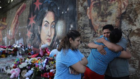 Marlen Ochoa-Lopez's father, Arnulfo Ochoa, gets a surprise hug Wednesday from his 13-year-old son, Oscar, while visiting a mural of his slain daughter painted by Milton Coronado in Chicago. 