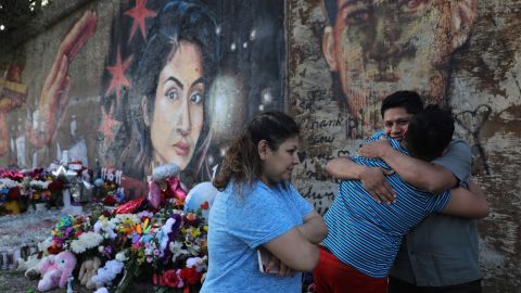 Marlen Ochoa-Lopez's father, Arnulfo Ochoa, gets a surprise hug Wednesday from his 13-year-old son, Oscar, while visiting a mural of his slain daughter painted by Milton Coronado in Chicago.