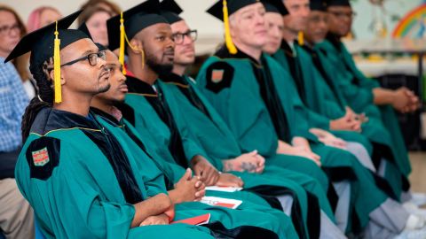 Larry Marshall (left) and fellow graduates sit at their commencement. They received Associate of Arts degrees from Washington University in St. Louis through the school's Prison Education Project.