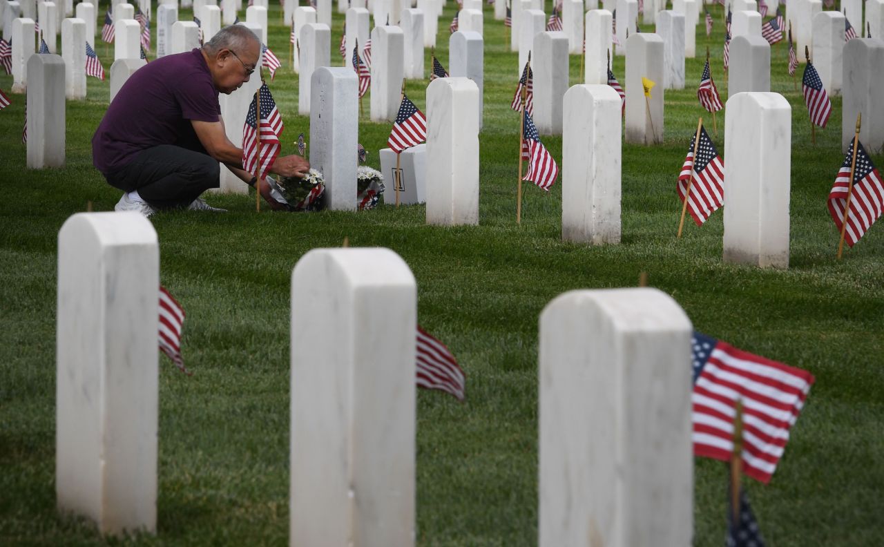 Paul Keneka leaves flowers beside the grave of his uncle, Noboru J. Muranaka, at the Los Angeles National Cemetery on Saturday, May 25. Volunteers placed 88,000 American flags on graves in preparation for Memorial Day.