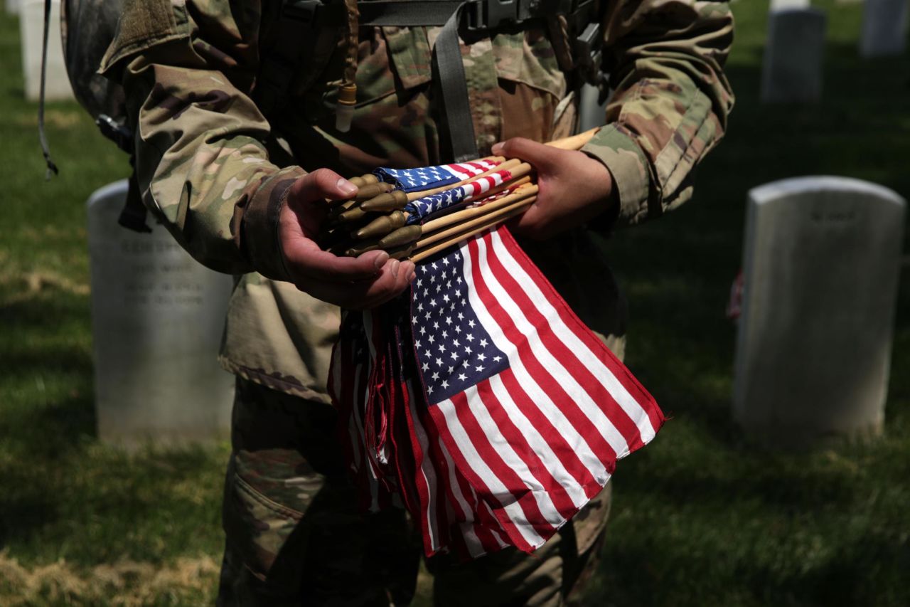 A soldier with the 3rd Infantry Regiment participates in the Flags In event at Arlington National Cemetery on May 23. The cemetery hosted the event to adorn the graves of US service members.