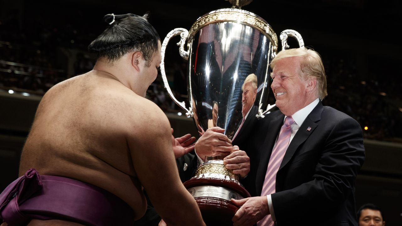 Donald Trump presents the President's Cup to the Tokyo Grand Sumo Tournament winner Asanoyama, at Ryogoku Kokugikan Stadium. 