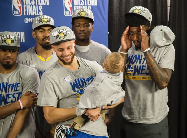 Golden State Warriors forward Jordan Bell, right, plays peek-a-boo with Canon Jack, the son of guard Stephen Curry, center, during an awards ceremony after the Warriors defeated the Portland Trail Blazers in Game 4 of the Western Conference Finals of the 2019 NBA Playoffs at the Moda Center in Portland, Oregon, on Monday, May 20.
