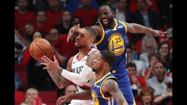Portland Trail Blazers guard Damian Lillard passes the ball past the hand of Golden State Warriors forward Draymond Green in the second half of Game 4 of the Western Conference Finals of the 2019 NBA Playoffs at the Moda Center in Portland, Oregon on Monday, May 20.