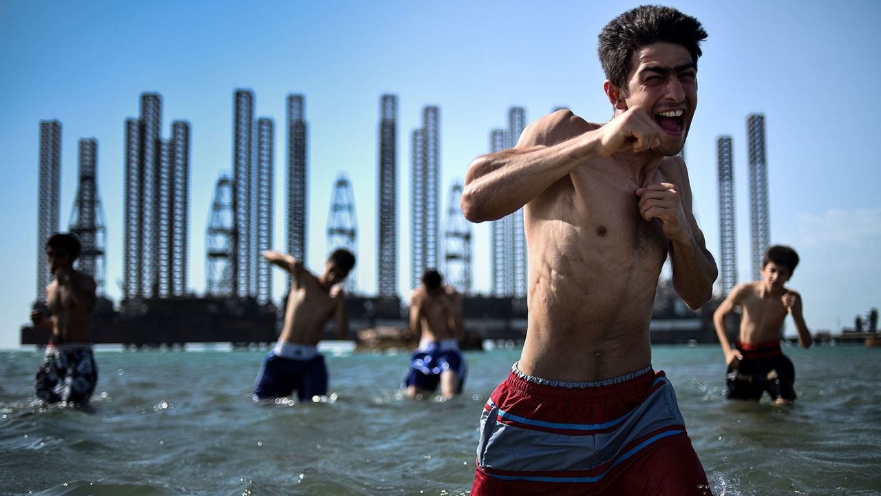 <strong>Resource-rich sea: </strong>Teens take part in a boxing training session in the waters off Baku. The oil rigs in a background is a reminder that the Caspian seabed is home to an estimated 50 billion barrels of oil reserve. 
