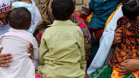 Pakistani women hold their HIV infected children as they gather at a house at Wasayo village in Rato Dero in the district of Larkana of the southern Sindh province on May 8, 2019. 