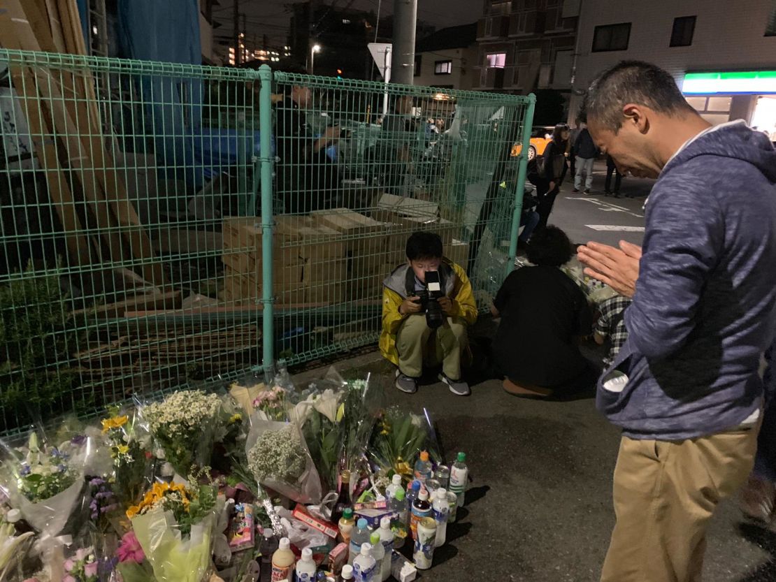 Local residents pray for the victims at the site where the stabbing occured on Tuesday night. 