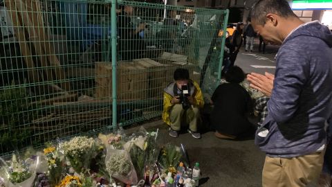 Local residents pray for the victims at the site where the stabbing occured on Tuesday night.