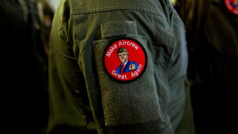 A service member wears a patch that says "Make Aircrew Great Again" while listening to President Donald Trump speak to service members aboard the USS Wasp on May 28.