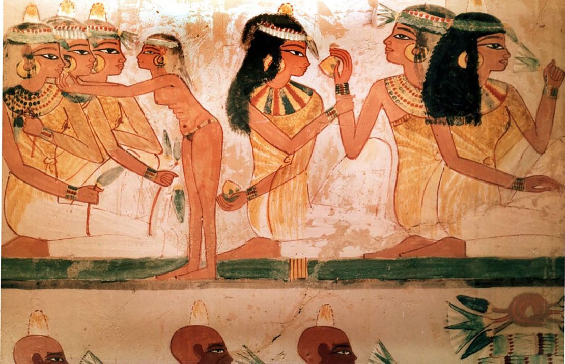 A detail of a painting from the tomb of Nakht depicting three ladies at a feast. They wear perfumed cones in their hair and elaborate necklaces. 