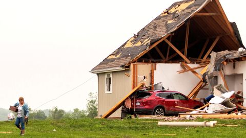 A woman walks away from a damaged house after several tornadoes reportedly touched down, in Linwood, Kansas, on May 29, 2019.