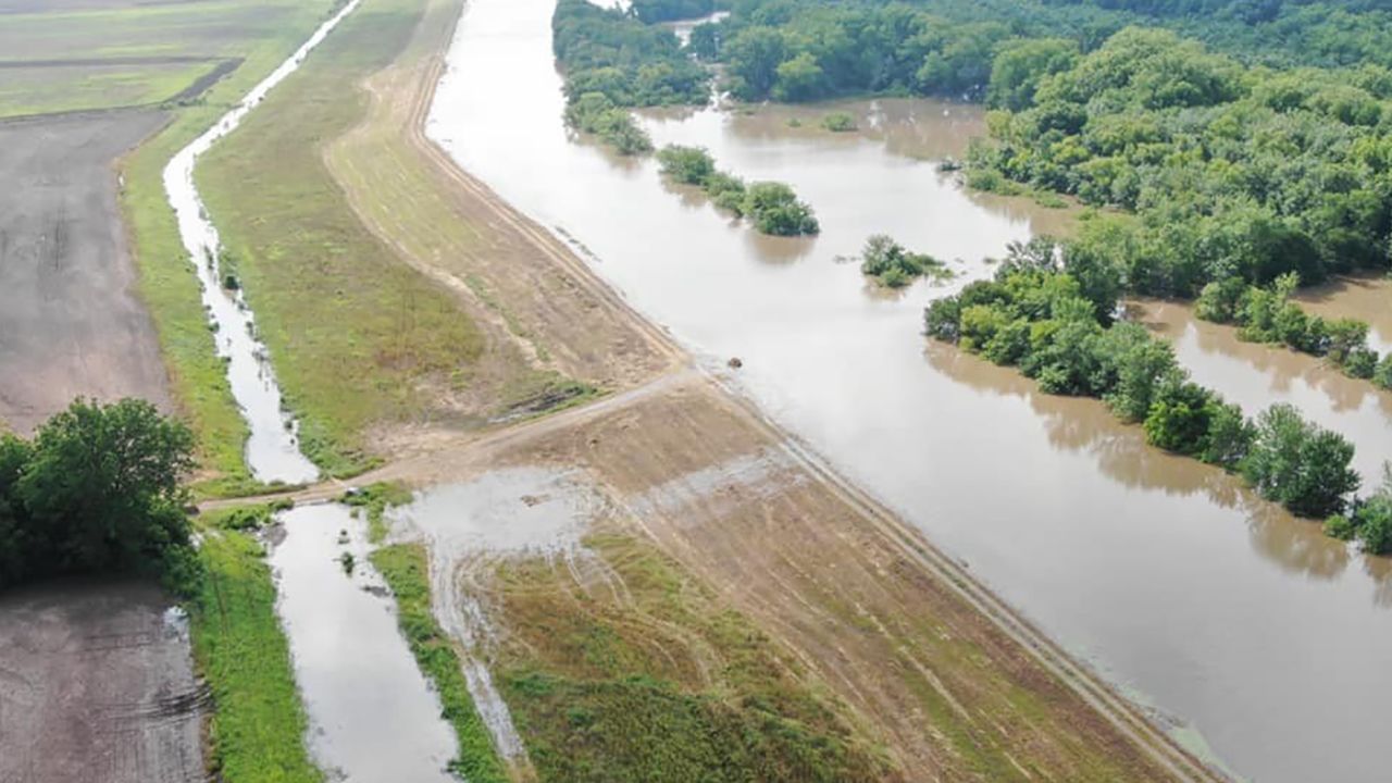 Water overtops a levee in Logan County, Arkansas, near state Highway 309, drone footage shows. 