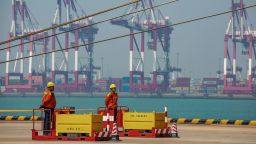 Two staff members stand at a port in Qingdao in China's eastern Shandong province on April 17, 2019. - China's economy beat forecasts as it remained steady with 6.4 percent growth in the first quarter amid tepid global demand, a US trade war and a debt battle, official data showed on April 17. (Photo by STR / AFP) / China OUT        (Photo credit should read STR/AFP/Getty Images)