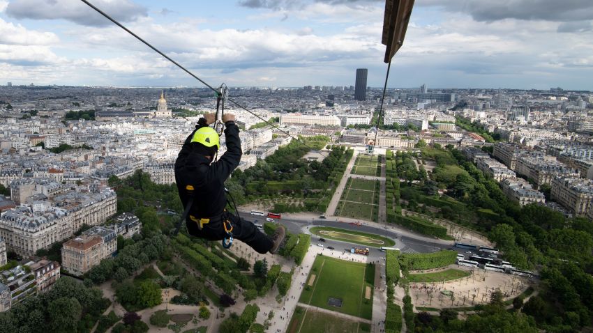 TOPSHOT - A person rides on a zip-line descending from the second floor of the Eiffel Tower on May 28, 2019 in Paris. - The 800 meter crossing takes one minute at a speed of 90km/h. The zip-line will be opened from May 29 to June 2, 2019. (Photo by Eric Feferberg / AFP)        (Photo credit should read ERIC FEFERBERG/AFP/Getty Images)