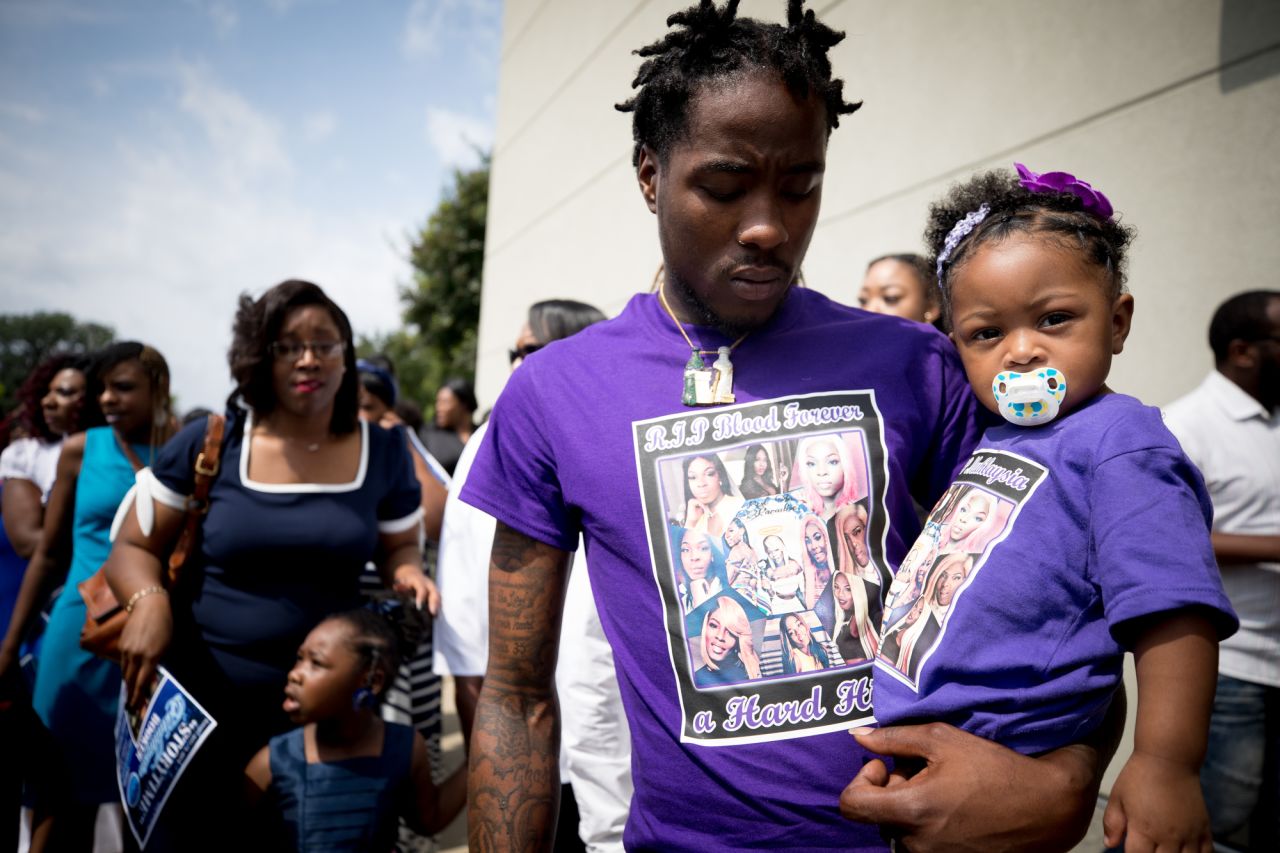 Booker was well known in South Dallas, where the city's black transgender community is concentrated. Funeral guests made custom shirts in honor of Booker, including Booker's cousin Charles Hart, seen here with his 1-year-old daughter.