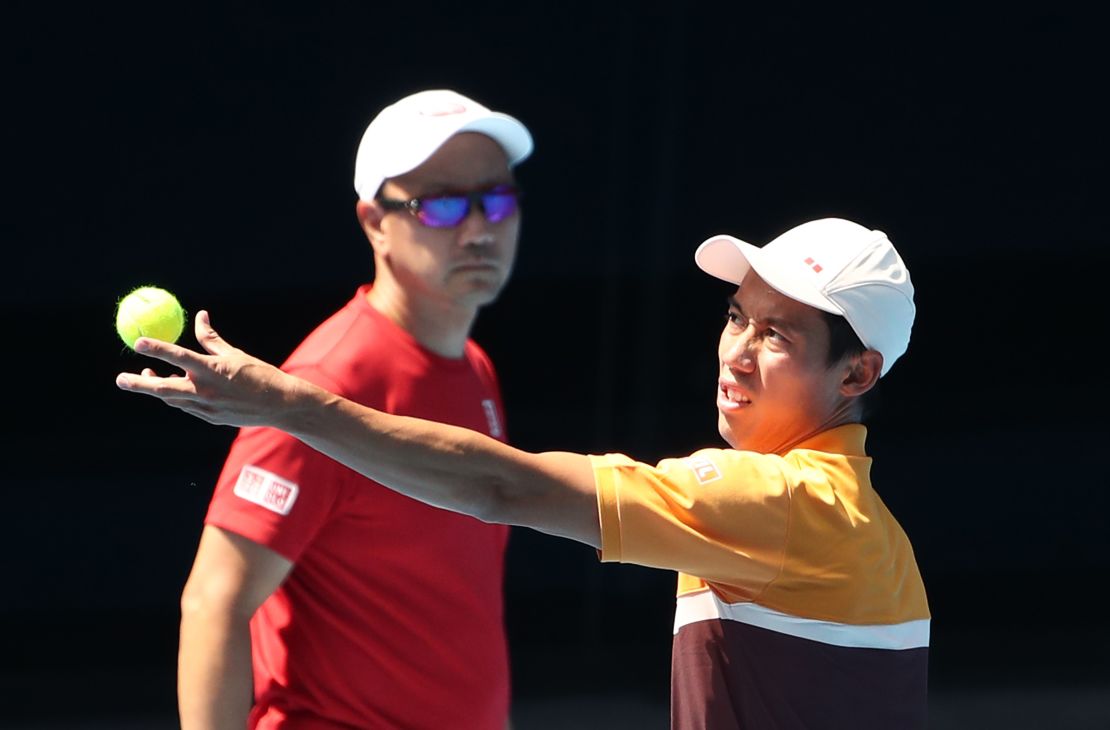 Nishikori serves as Chang looks on during a practice session in Melbourne, Australia in January.