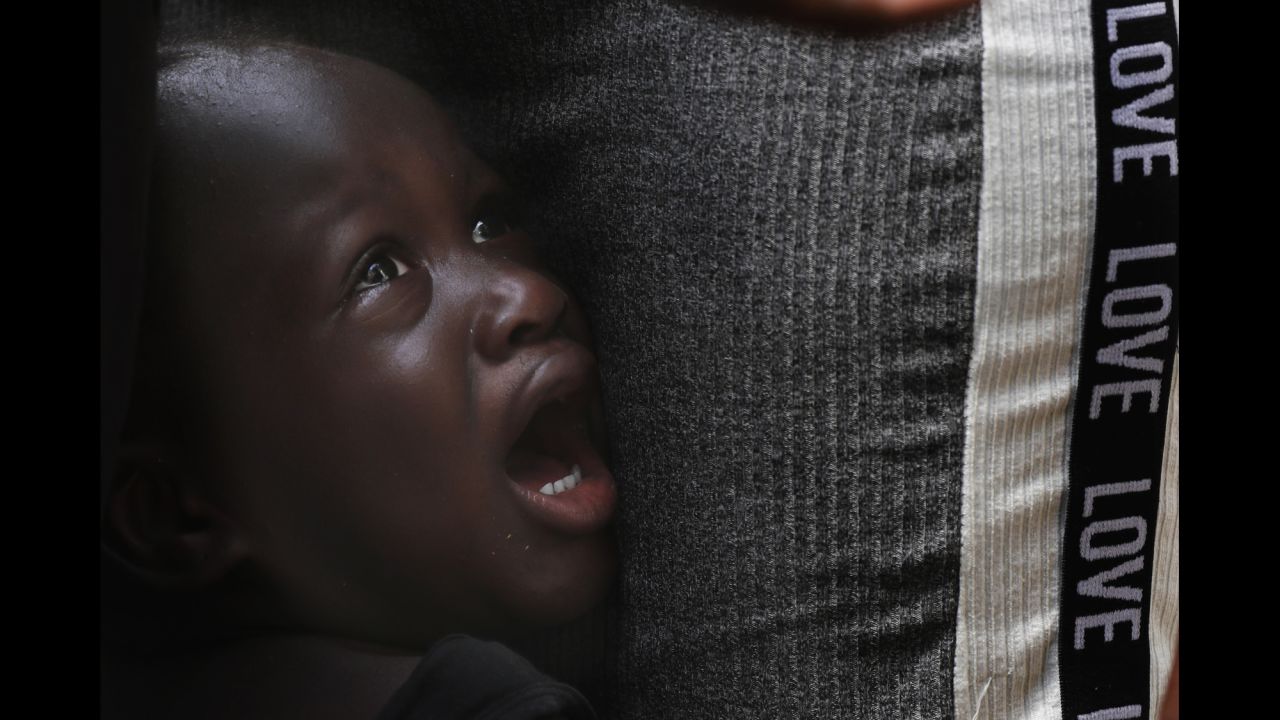 A young migrant from Haiti cries next to his father as they wait at an immigration center in Tapachula, Mexico, on Tuesday, May 28.