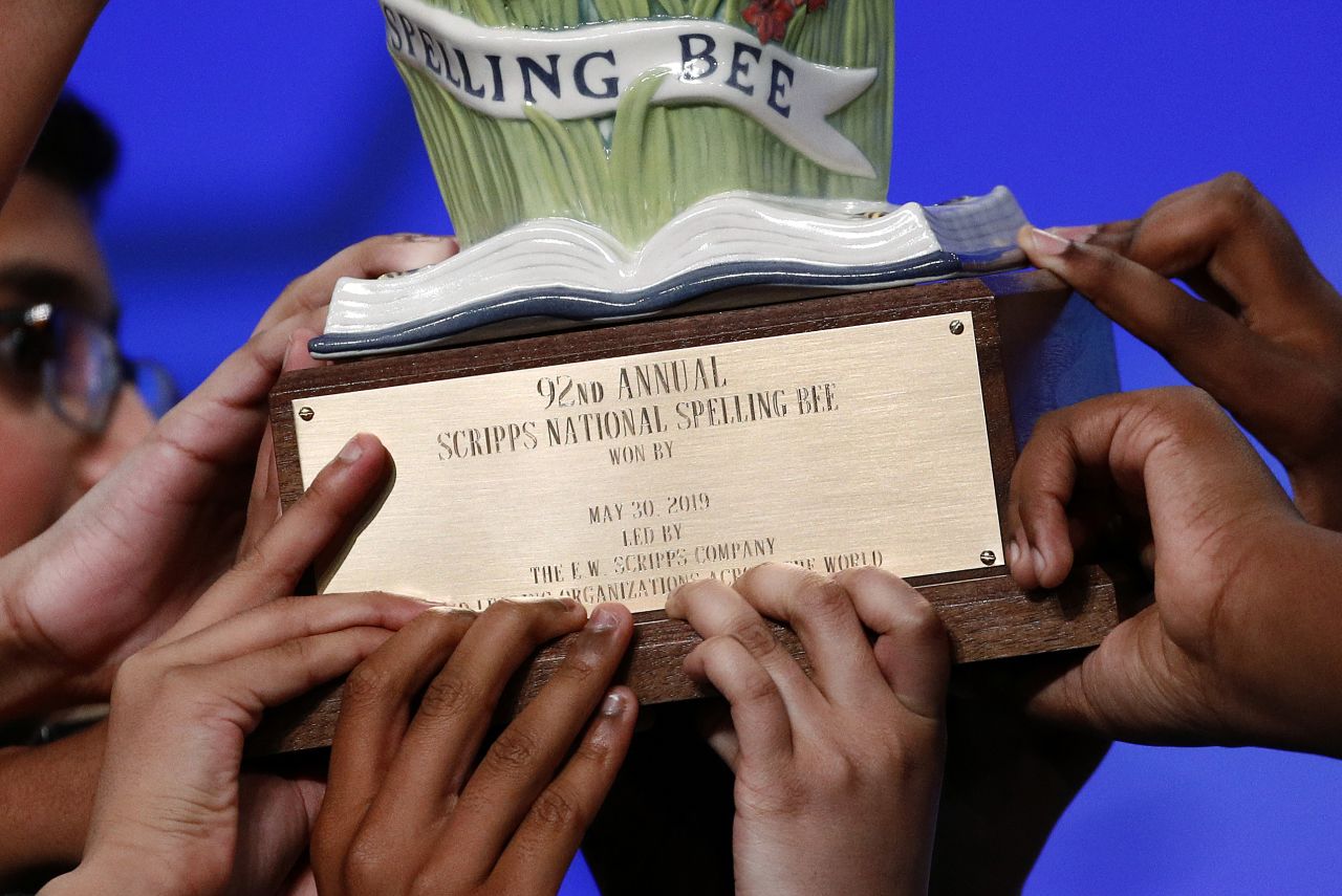 Eight co-champions carry a trophy after winning the 2019 Scripps National Spelling Bee, early Friday in Oxon Hill, Maryland. Each will get the full winner's prize of $50,000 in cash.
