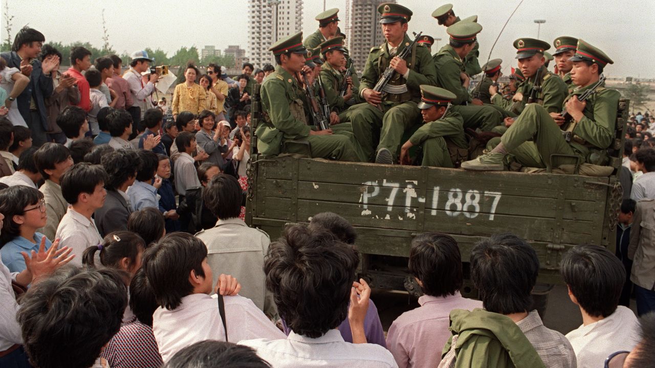 Pro-democracy demonstrators surround a truck filled of People's Liberation Army (PLO) soldiers on 20 May 1989 in Beijing on their way to Tiananmen Square.