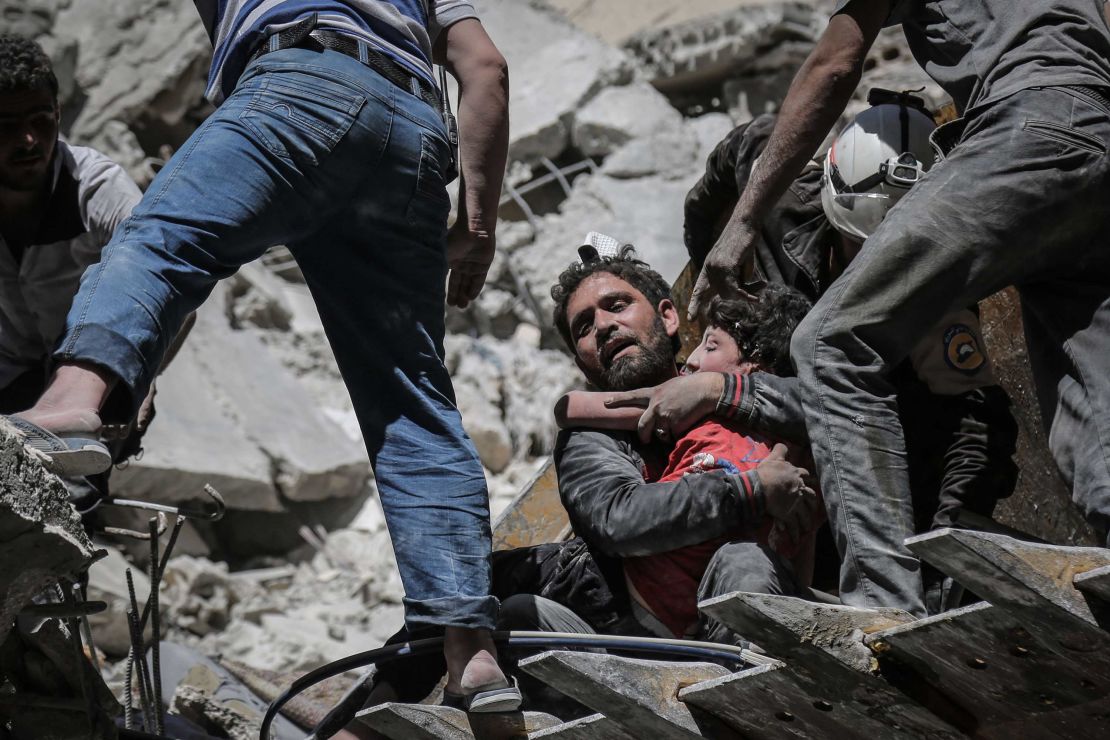 Nour Faham is carried from the rubble of a building destroyed during an airstrike in Ariha on May 27.