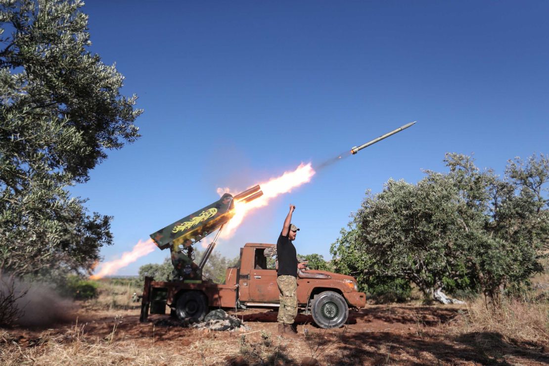 A Syrian fighter from the Turkish-backed National Liberation Front fires a heavy artillery gun from the jihadist-held Idlib province against regime positions in Hama province, on May 26.