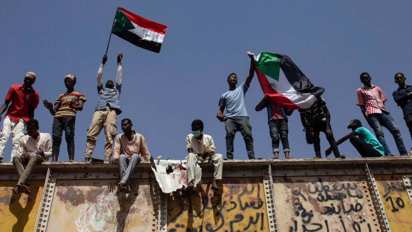 FILE - In this May 2, 2019, file photo, Sudanese protesters wave national flags at the sit-in outside the military headquarters, in Khartoum, Sudan. The satellite news channel Al-Jazeera said Friday, May 31, 2019, that Sudan shut down its bureau, just as the country's military government warned that the Khartoum sit-in that help bring ruler Omar al-Bashir's ouster had "become a threat to the revolution." (AP Photos/Salih Basheer, File)