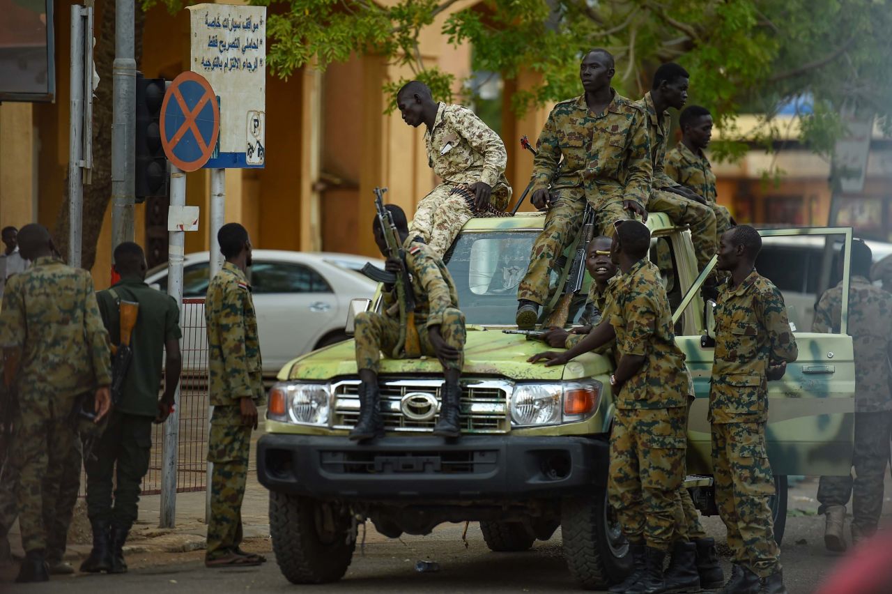 Sudanese army soldiers gather as people rally in front of the Presidential Palace in downtown Khartoum on May 18.