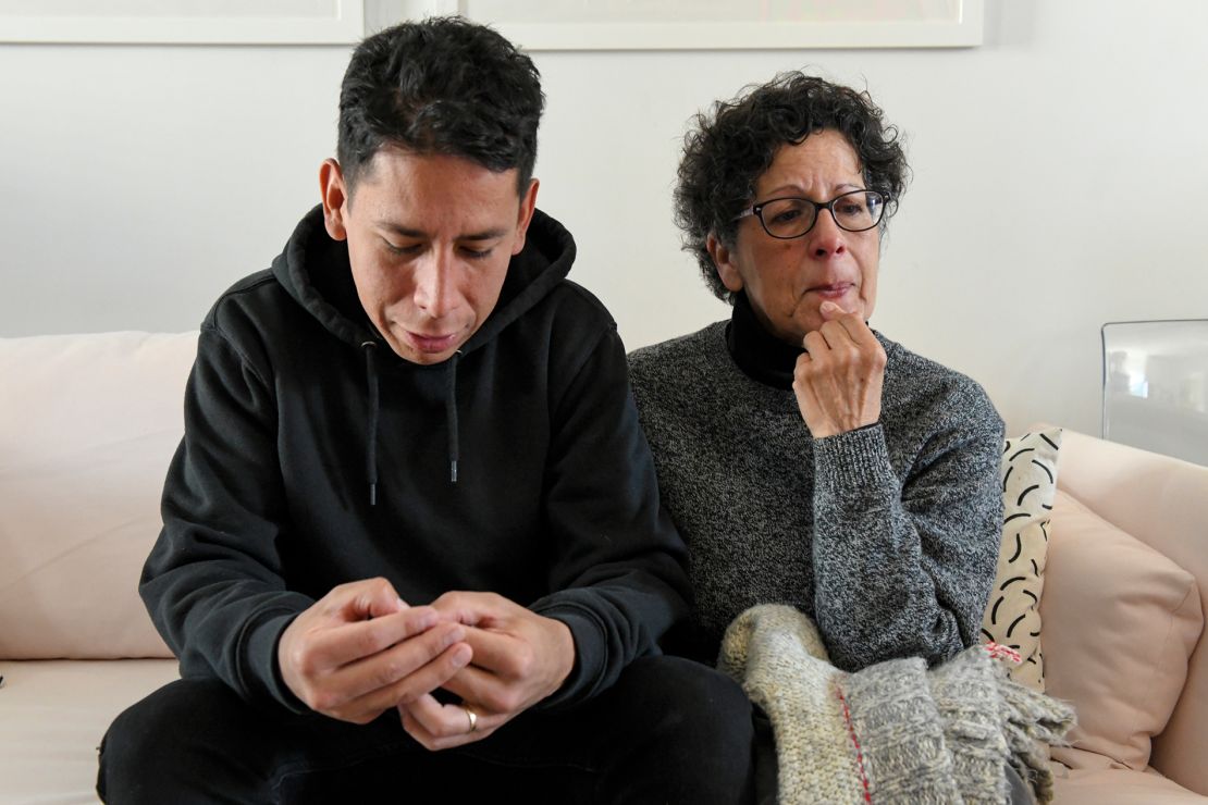 Carlos Jr. and his mother Maria, holding Carla's favorite sweater, at his home in Brooklyn.