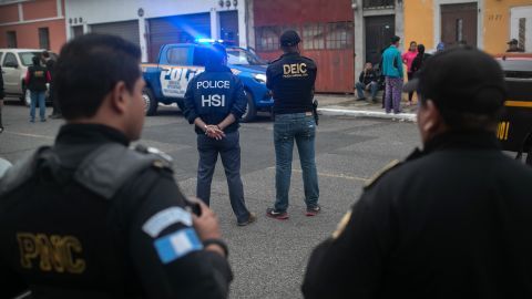 ICE agents with U.S. Homeland Security Investigations, and Guatemalan police stand at the scene of an early morning raid where a suspected human trafficker was taken into custody on May 29, 2019, in Guatemala City.