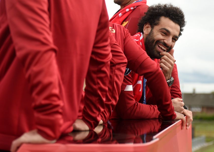 Mo Salah smiles from the roof of the bus to greet the gathered fan base. 