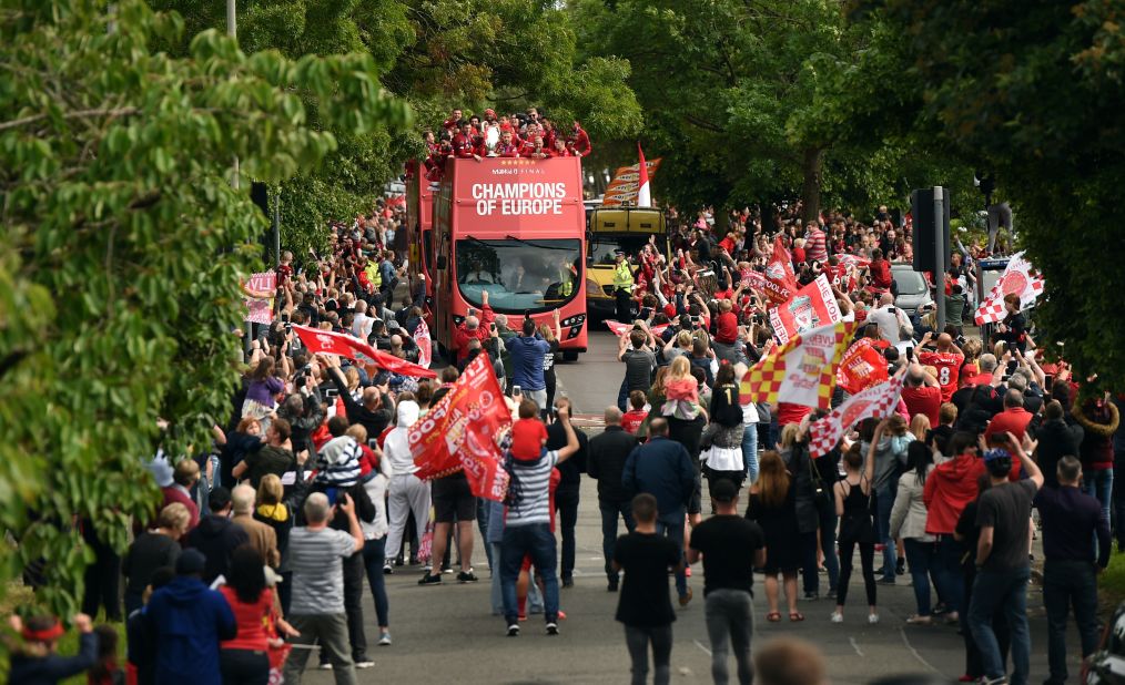 Liverpool fans line the streets as Liverpool's English midfielder Jordan Henderson holds the European Champion Clubs' Cup trophy on Sunday. 