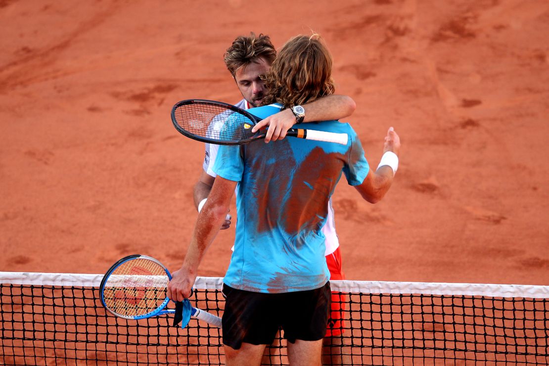 Stan Wawrinka and Stefanos Tsitsipas (blue shirt) embrace after their French Open marathon. 