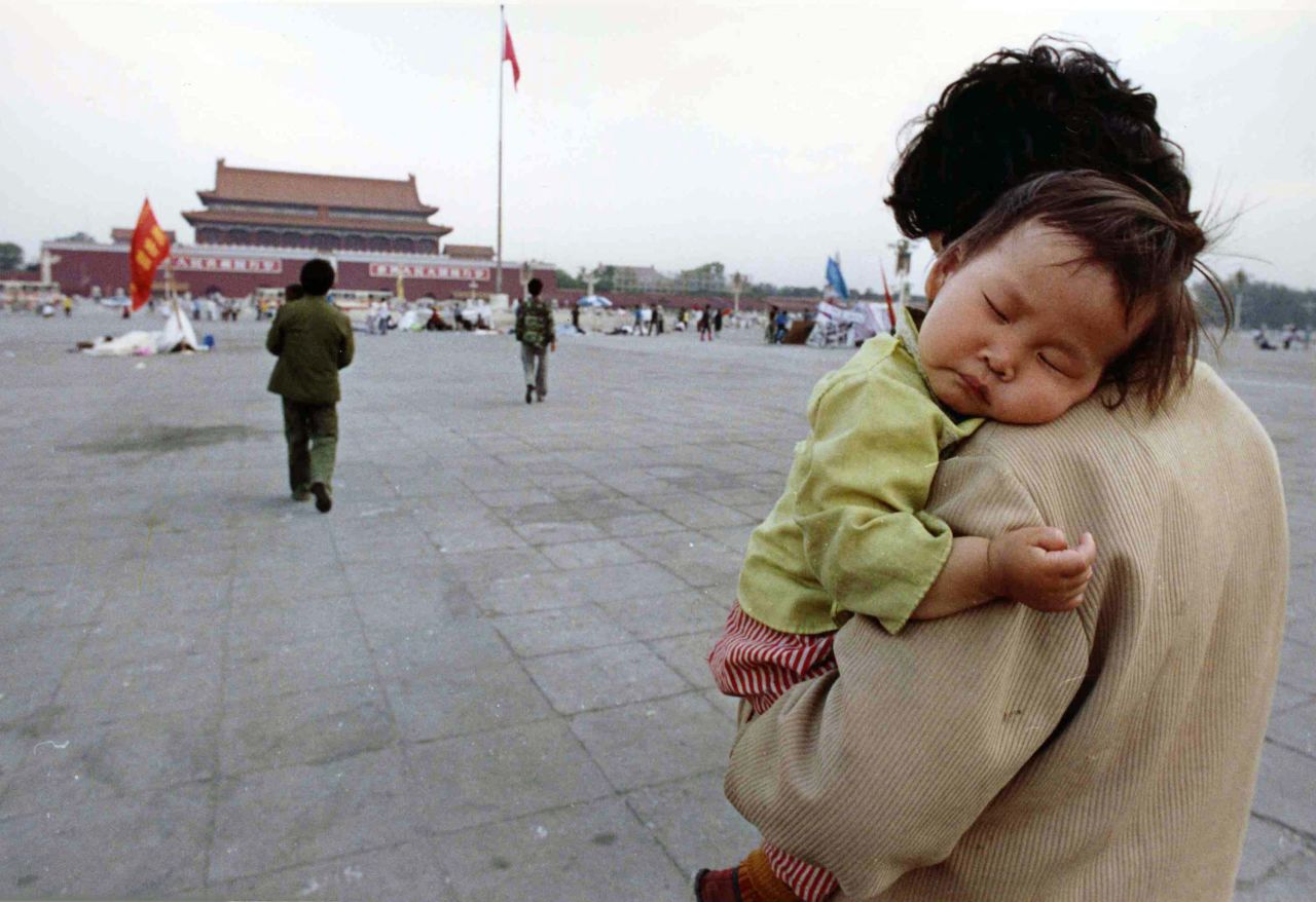 A child sleeps on his mother's shoulder as she crosses Tiananmen Square in May 1989.