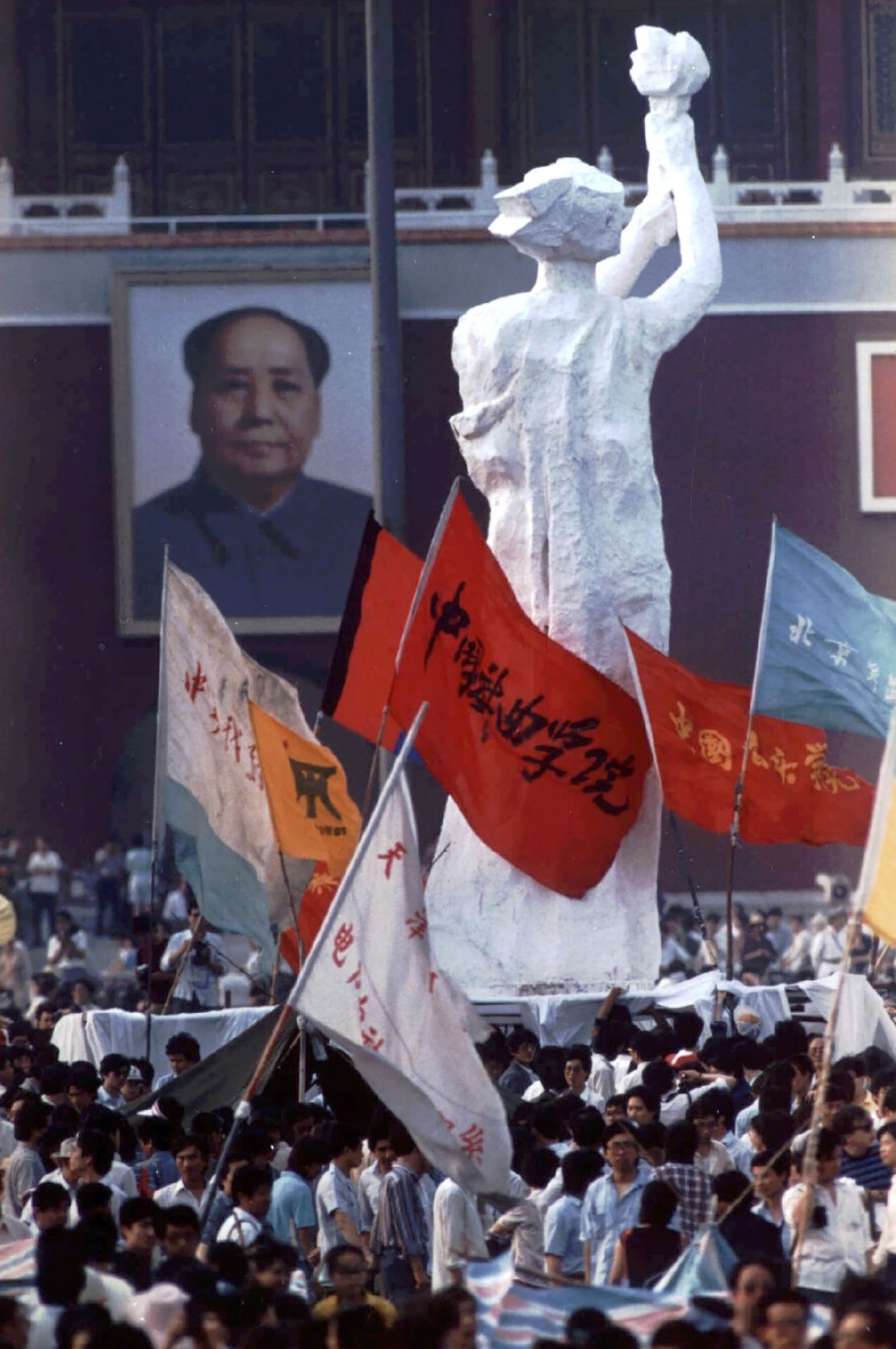 The "Goddess of Democracy" faces off with a portrait of Mao Zedong hanging at the entrance to the Forbidden City.