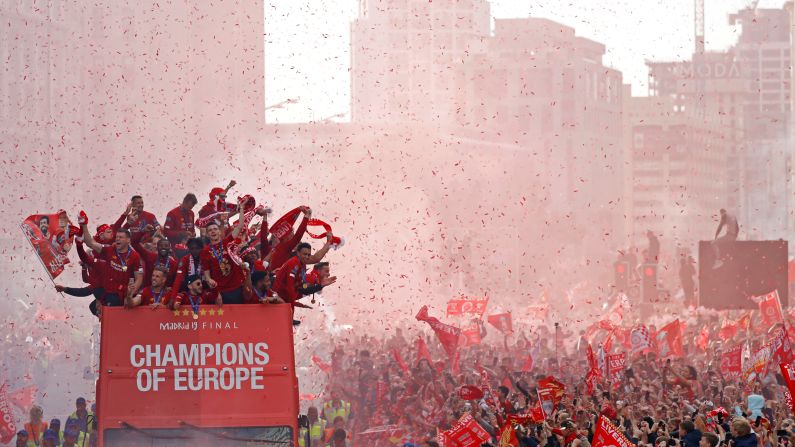 Liverpool players celebrate on top of a team bus surrounded by cheering fans during a parade to celebrate their <a href="index.php?page=&url=https%3A%2F%2Fwww.cnn.com%2F2019%2F06%2F01%2Ffootball%2Fchampions-league-final-result-liverpool-tottenham-spt-intl%2Findex.html" target="_blank">Champions League title</a> in Liverpool, England, on Sunday, June 2.