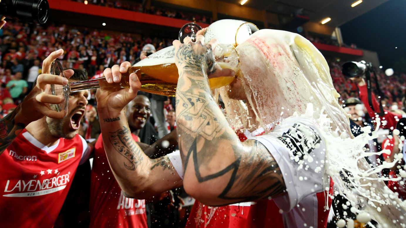 Union Berlin players drench themselves in beer in celebration after a match against VfB Stuttgart in Berlin, Germany, on Monday, May 27. Union Berlin was celebrating their promotion to the Bundesliga, the top flight of German soccer.