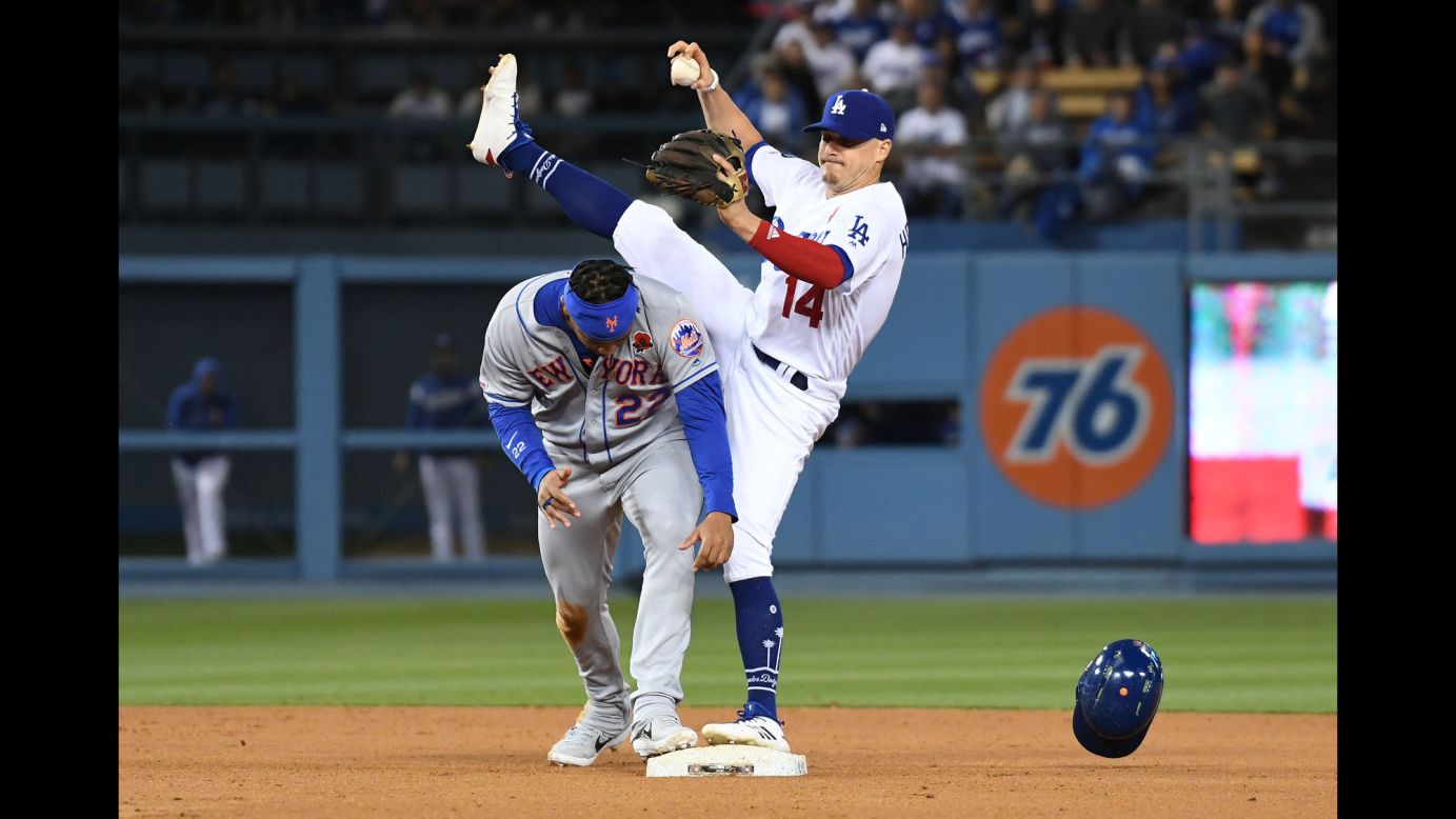 New York Mets first baseman Dominic Smith ducks under the leg of Los Angeles Dodgers center fielder Enrique Hernandez after being called out at second base during the eighth inning of their game at Dodger Stadium in Los Angeles on Monday, May 27.