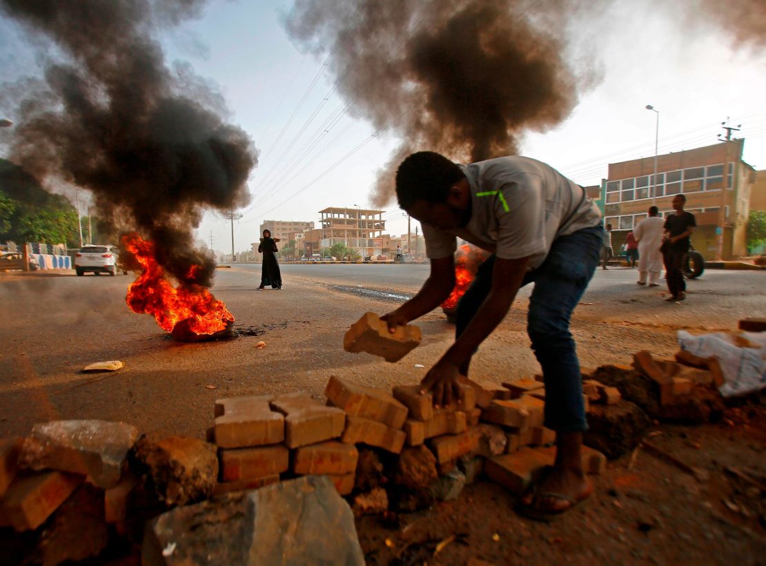 A Sudanese protester uses paving stones to block Street 60 as military forces tried to disperse a sit-in on June 3, 2019. 