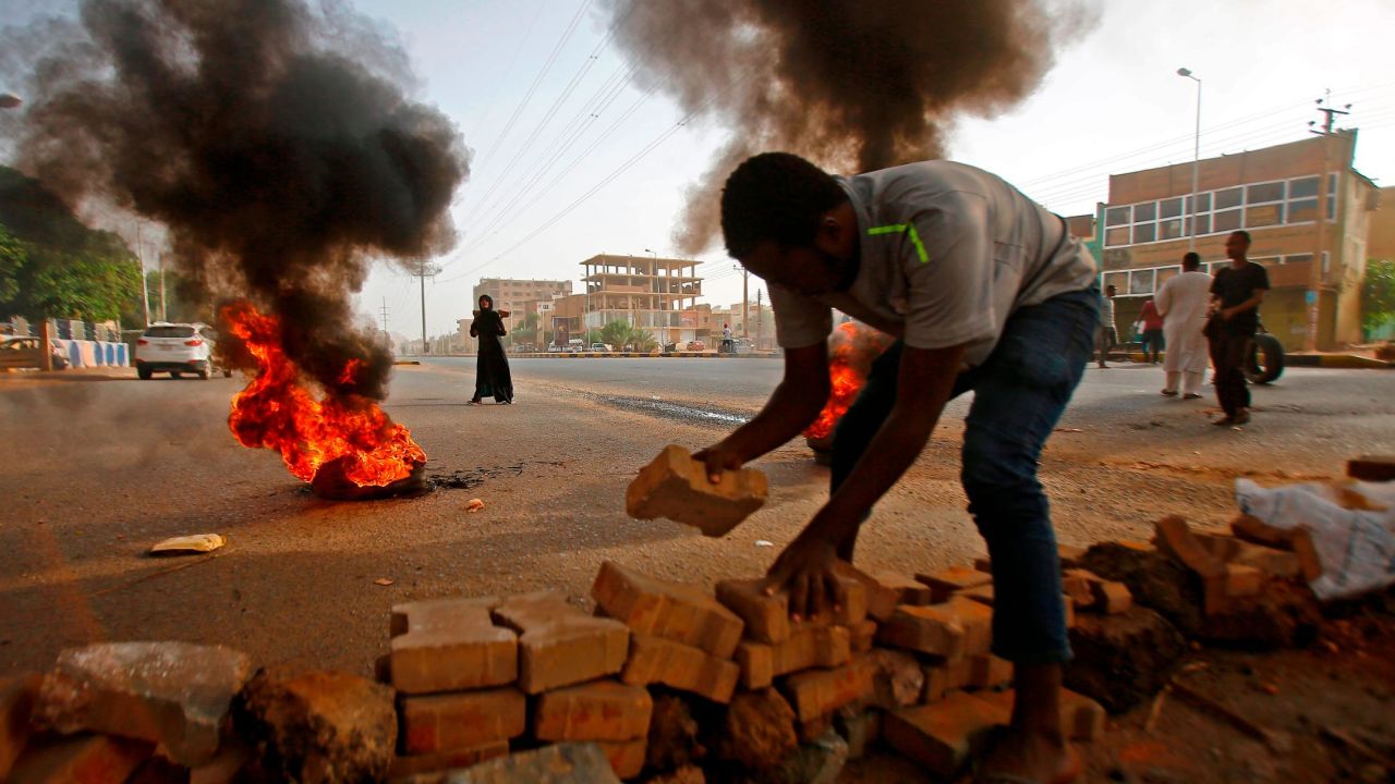 A Sudanese protester uses paving stones to block Street 60 as military forces tried to disperse a sit-in on June 3, 2019.
