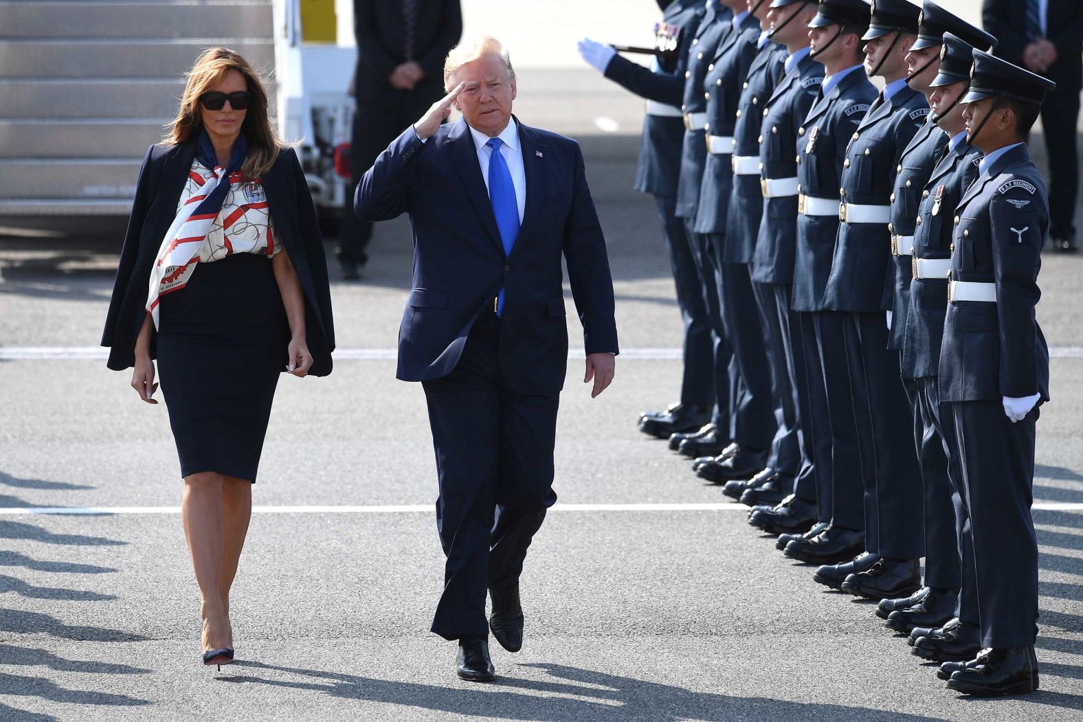 The President salutes troops as he and the first lady arrive at Stansted Airport.
