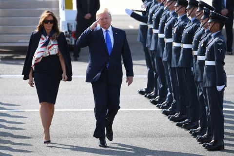 The President salutes troops as he and the first lady arrive at Stansted Airport.