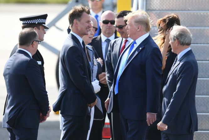 Trump is greeted by UK Foreign Secretary Jeremy Hunt after arriving at the airport.