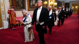 Britain's Queen Elizabeth II (L) walks with US President Donald Trump (C) and other guests as they arrive through the East Gallery during a State Banquet in the ballroom at Buckingham Palace in central London on June 3, 2019, on the first day of the US president and First Lady's three-day State Visit to the UK. - Britain rolled out the red carpet for US President Donald Trump on June 3 as he arrived in Britain for a state visit already overshadowed by his outspoken remarks on Brexit. (Photo by Victoria Jones / POOL / AFP)        (Photo credit should read VICTORIA JONES/AFP/Getty Images)