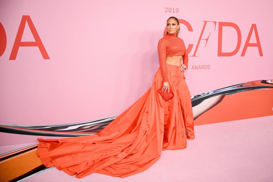 Jennifer Lopez wears a coral Ralph Lauren dress at the CFDA Awards, where she was recognized for her impact on fashion. Scroll through to see more looks from the red carpet. 