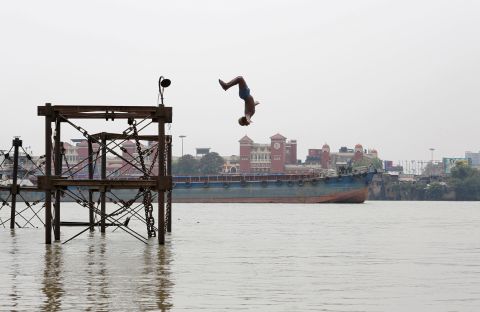 A boy jumps into the Ganges River to cool off on a hot summer day in Kolkata, India, on Monday, June 3. 